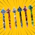 Canetas Plug com personagens de heróis, incluindo Capitão América, Iron Man, Thor, Batman, Homem-Aranha e Hulk, sobre fundo amarelo.
