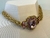 COLAR DOURADO COM PINGENTE DE CRISTAL ROSA E DETALHES EM PEDRAS - comprar online