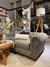 Sillon de dos y tres cuerpos chestefield con capitone en color gris acompañado de objetos decorativos en un local comercial 