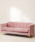 Sillón de dos/tres cuerpos de color rosa, con un diseño elegante y moderno, tapizado en terciopelo y con patas de madera.
