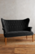 Sillón de dos cuerpos Rivona en color negro con respaldo alto y patas de madera.