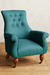 Sillón de un cuerpo Astrid en color verde con botones en el respaldo y patas de madera.