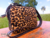 Bolsa transversal em couro legítimo com estampa de onça, da marca Cincow, destacando seu design elegante.