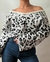 Poleron tejido de animal print en blanco y negro, con un diseño moderno y mangas amplias, usado con jeans ajustados.