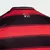 Detalhe das listras vermelhas e pretas da camisa I Flamengo 25/25 com o logo do clube na parte de trás.