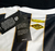 Detalhe da parte de trás da camisa do Santos, mostrando o logo da Vila Belmiro e etiquetas de identificação do produto.