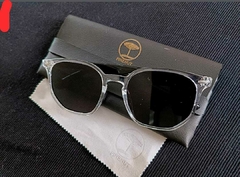 Óculos de sol hexagonais PARIS com lentes escuras sobre um pano e estojo da marca Pinenut.