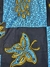 Buba y Shokoto con detalle de mariposa y capullos azules con amarillo con fondo azul munsell y marino en internet