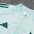 Conjunto de agasalho masculino da Adidas, na cor verde claro, composto por uma blusa de manga longa e calças, com detalhes do time Cruzeiro.