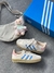 Tênis Adidas Gazelle bege com rosa e detalhe azul na internet
