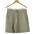 Shorts sarja bege Jeane Steiner pendurados em cabide, com dois botões na frente e pregas laterais.