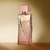 Frasco de perfume feminino de 25ml com design elegante e moderno, cor rosa e tampa dourada.