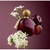 Frasco de perfume Avon Far Away Splendoria, decorado com flores brancas e frutas, sobre fundo roxo.