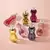 Conjunto de frascos de colônia Glamour em diferentes cores e formatos, apresentando a variedade de 75ml.