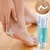 Mulher aplicando creme desodorante para os pés Foot Works da Avon em um pé.