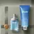 Frasco de perfume Natura Masculino Kaiak Tradicional de 25ml ao lado de um gel de barbear 2 em 1 de 100g, sobre fundo neutro.