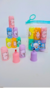 Conjunto de marca-textos coloridos com personagens fofos em tubos, incluindo rosa, roxo, azul e amarelo, organizados em uma mesa.