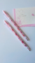 Dupla de lapiseiras Florida Love All com design floral em tons de rosa, ao lado de um bloco de notas com a palavra 'Amor'.