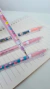 Conjunto de lapiseiras Florida Love All em cores vibrantes sobre um caderno com folhas em branco.