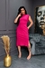Mulher usando um vestido rosa com bolso, posando em uma sala com decoração moderna.