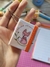 Chaveiro Post-it RapoMella com ilustração de raposa e frase inspiradora, segurado por uma mão.