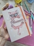 Um planner com a ilustração de um gato usando óculos, segurando uma prateleira com o título "Planner" em destaque. O fundo é decorado com patas de gato.