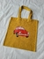 Sacola ecobag amarela com bordado de um carro Fusca vermelho.