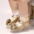 Sapato para bebê dourado estilo princesa.