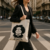 Mujer caminando por la ciudad con tote bag color natural con diseño en negro de Mafalda, personaje icónico de Quino