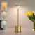 Luminária touch recarregável de LED em metal dourado com base cilíndrica.