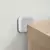 Protetor anti-impacto de silicone branco fixado na parede ao lado de um móvel de madeira