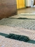 Tapete de piso com padrões de texturas em tons de bege e verde.