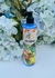 Botella de Keratina Capilar Frutal de 320 gr con tapa dispensadora, rodeada de flores blancas.