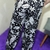 Calça pantalona estampada em preto e branco, com desenhos de flores, folhas e animais.