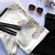 Blusa Cropped Tshirt Adidas branca com listras pretas na manga.