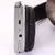 Detalhe do fone de ouvido sem fio bege, mostrando os botões de controle e entradas USB e AUX.