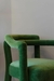 Poltrona Nudo de color verde, con un diseño moderno y elegante, destacando sus brazos curvos y tapizado suave.