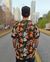 Camisa masculina estampada da marca Lazza. O modelo Brisada é preto com estampa florida azul, laranja, branca e verde.