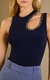 Um close-up de uma modelo vestindo um body de tricot azul marinho. O body possui um design assimétrico com um recorte na parte superior, expondo parte do ombro e da clavícula. Ao redor desse recorte, há uma aplicação de elementos brilhantes, criando um de