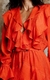 A imagem mostra um vestido curto bem em destaque, na cor coral de babados boho.