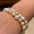 Pulseira de 20cm com pérolas brancas e alaranjadas tipo "batata" (8-10mm) com fecho tipo boia banhado a ouro branco - comprar online