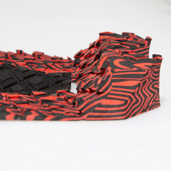 Deck de surf FCS Pro Model Filipe Toledo com design em preto e vermelho, destacando sua textura e formato inovador.