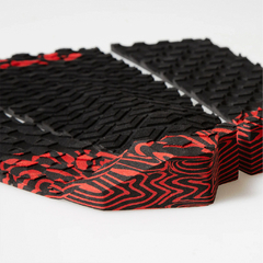 Deck de surf FCS Pro Model Filipe Toledo com design em preto e vermelho, destacando a textura e o formato do produto.