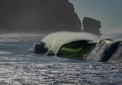 Onda perfeita quebrando em El Salvador, com spray suave ao vento e falésias ao fundo. Fotografia de Jaime Velho capturando a força e beleza do mar.