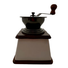 Moedor vintage com corpo de porcelana branca, manivela em metal e puxador em madeira, combina elegância e funcionalidade.