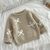 Sweater beige con moños en internet