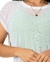 Modelo usando blusa em tela de malha branca, destacando detalhes do tecido e um colar dourado.