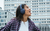 Mujer disfrutando de su música con JBL Tune 770 en una ciudad moderna.