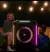 Altavoz JBL Encore Essential con luces LED en un ambiente festivo.