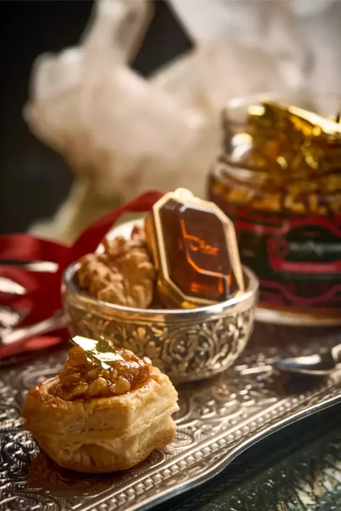 Antepasto de nozes douradas com ouro comestível, servido em pote de vidro gourmet